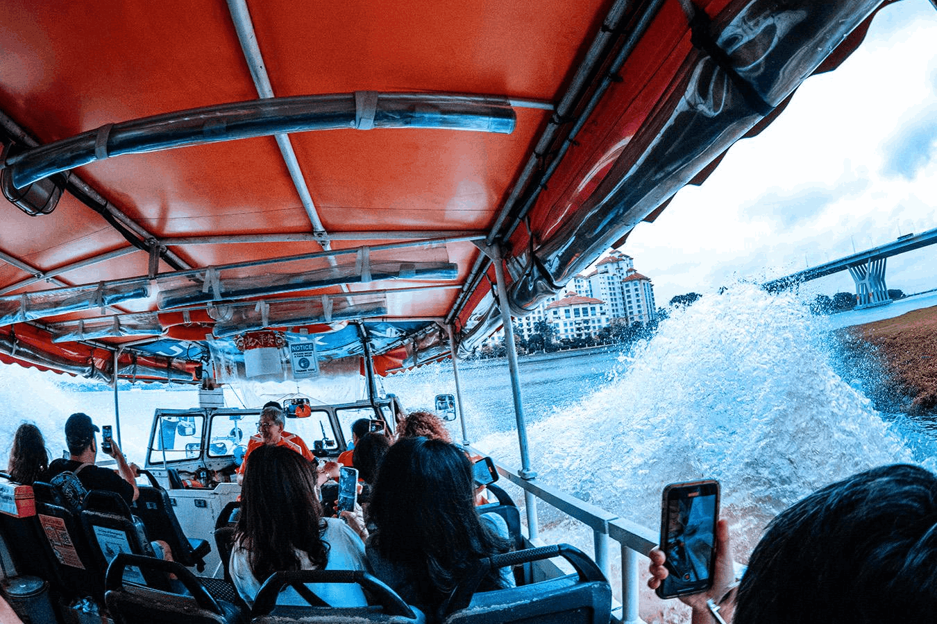 Passengers enjoying the Captain Explorer DUKW Tour as the amphibious vehicle splashes through the water in Singapore.