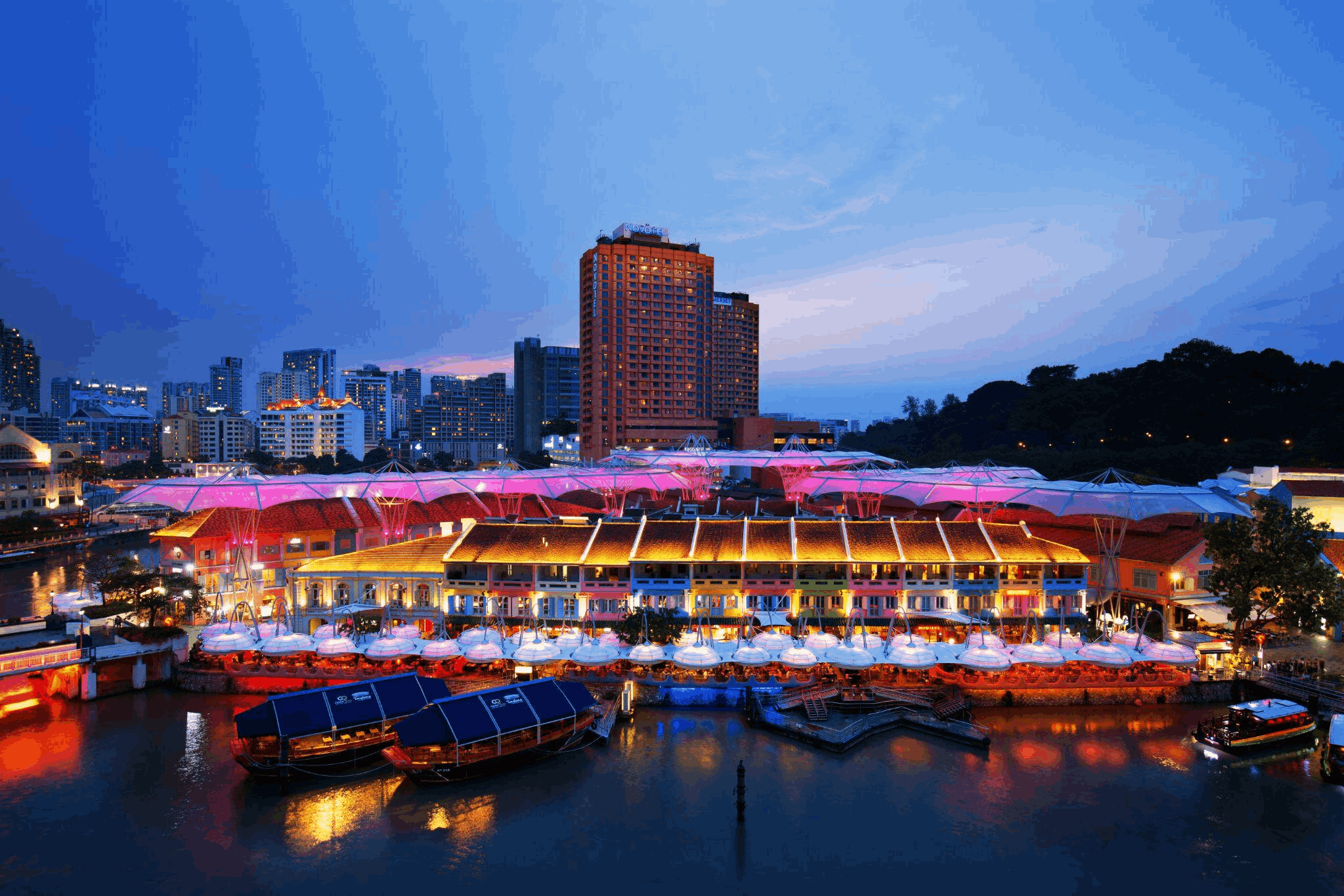 Boat Quay at night with riverside dining, city lights and Singapore skyline views, a lively evening spot for visitors exploring Singapore after dark.