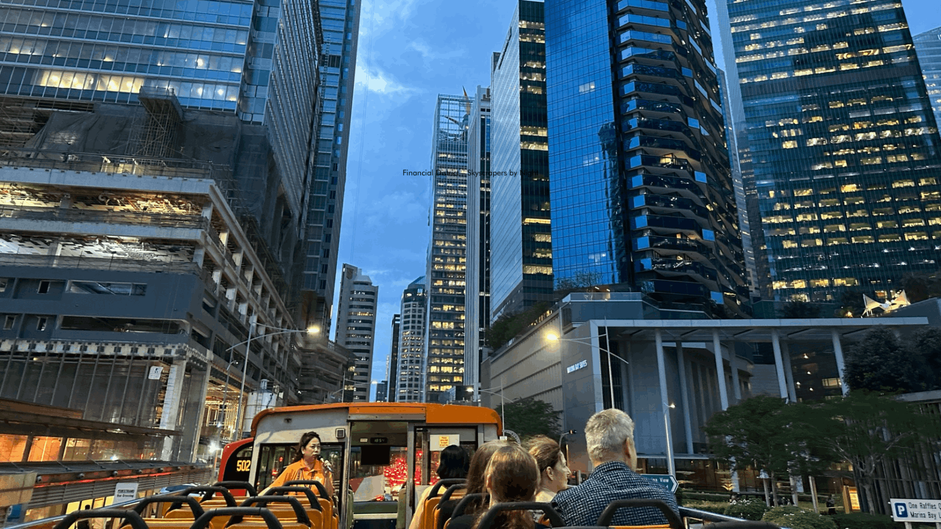 An English/Chinese-speaking guide sharing fascinating legends and history with passengers on the top deck of a FunVee open-top bus during the Chinatown Light Up Tour.
