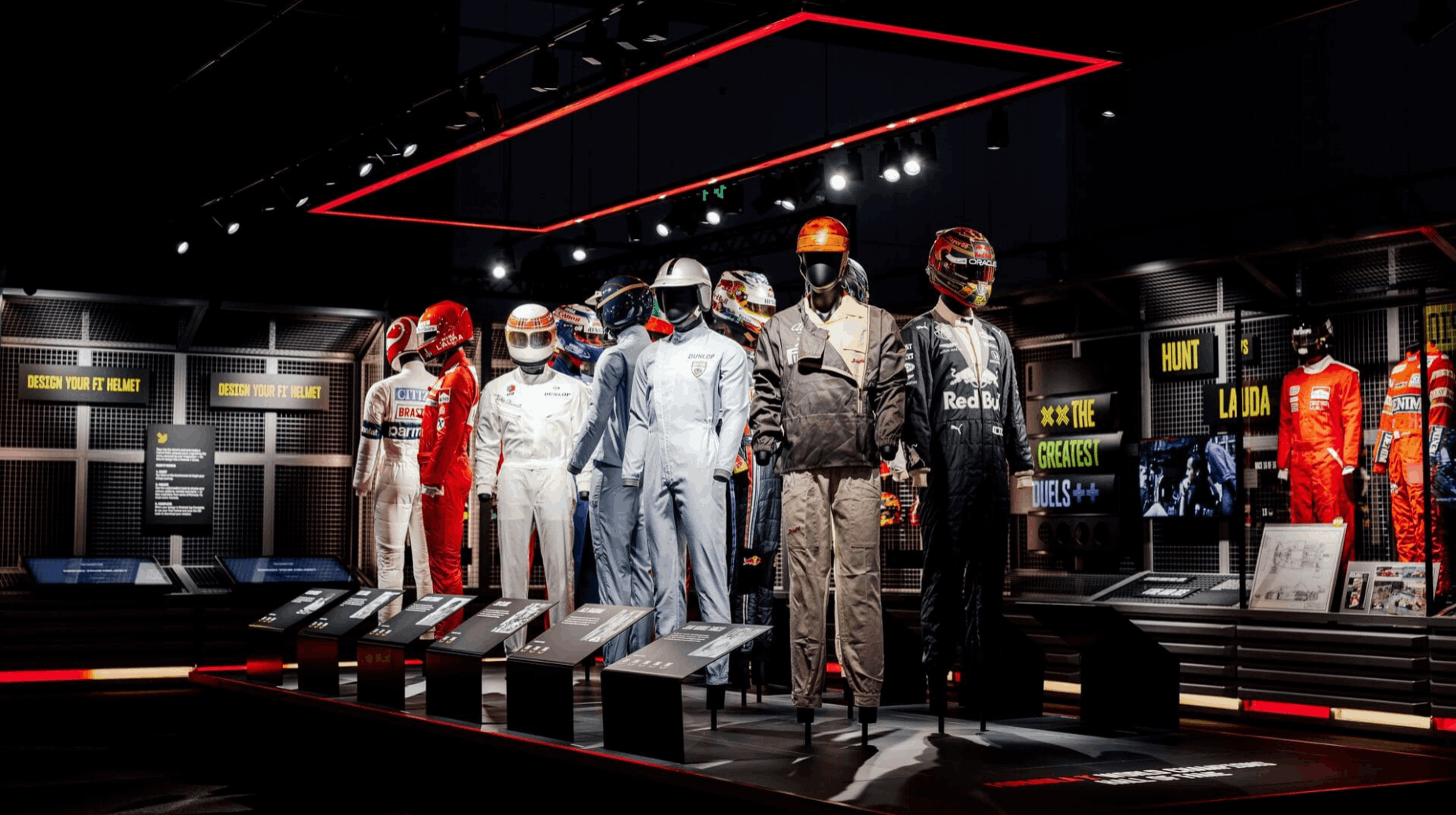Historic Formula 1 racing suits and helmets displayed at the Formula 1 Exhibition Singapore.