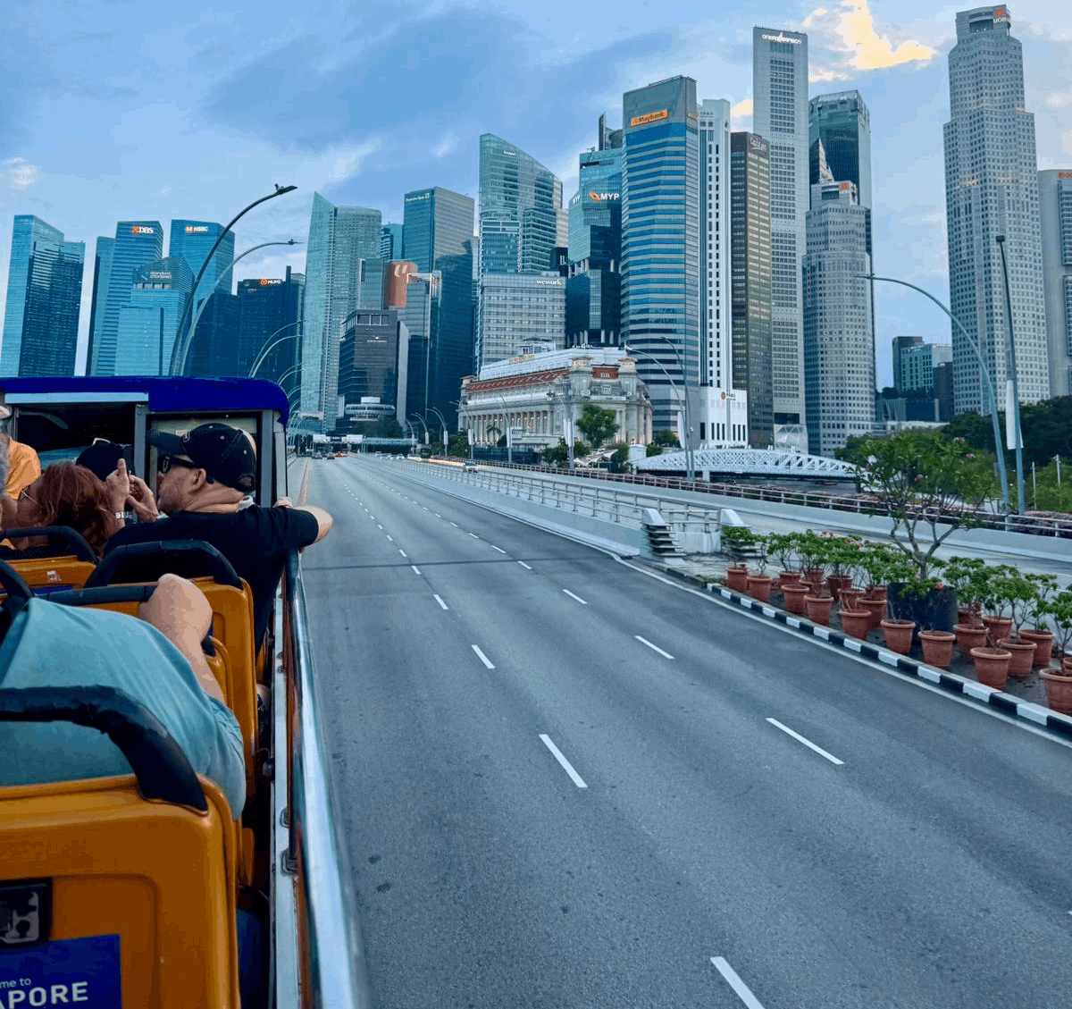 Passengers on a FunVee Open-Top Bus enjoying views of Singapore’s city skyline and financial district.