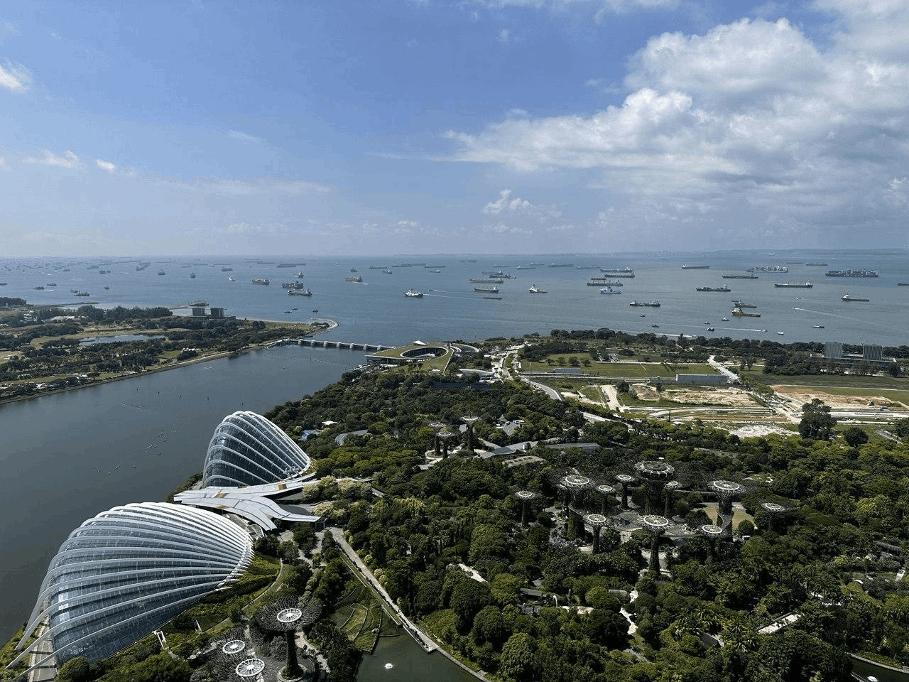 View from Marina Bay Sands SkyPark overlooking Gardens by the Bay, Supertree Grove and Singapore’s waterfront, a top attraction for first-time visitors.