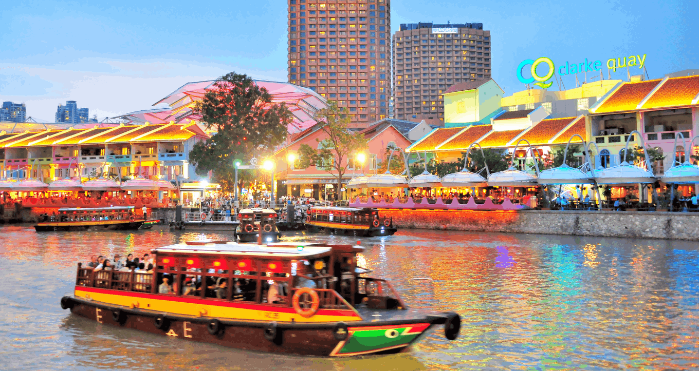 Singapore River Cruise passing Clarke Quay at night, included in Singapore City Lights Open-Top bus ride, a scenic way to enjoy the city lights and riverside atmosphere after dark.