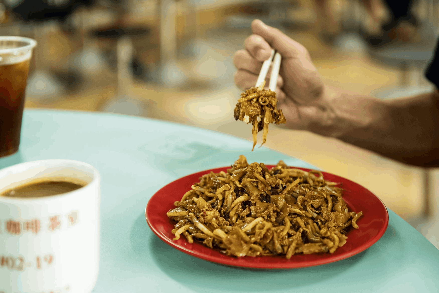 A plate of char kway teow at Zion Riverside Food Centre in Singapore, featuring stir-fried flat noodles with prawns and egg.