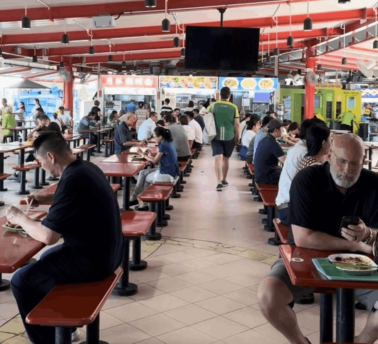 Diners enjoying local dishes at Zion Riverside Food Centre in Singapore, a popular hawker spot by the Singapore River known for its char kway teow and prawn noodles.